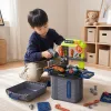 A grey TRAVEL box-style 3-in-1 toy tool set with a blue handle and travel logo, including a green workbench, an orange saw and a blue electric drill details Picture